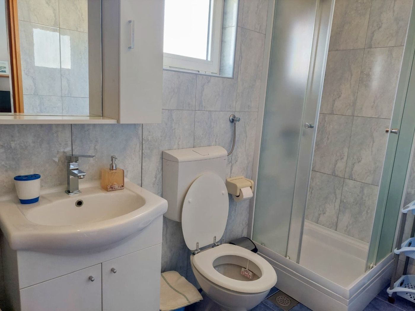 Un baño con lavamanos, inodoro y ducha.