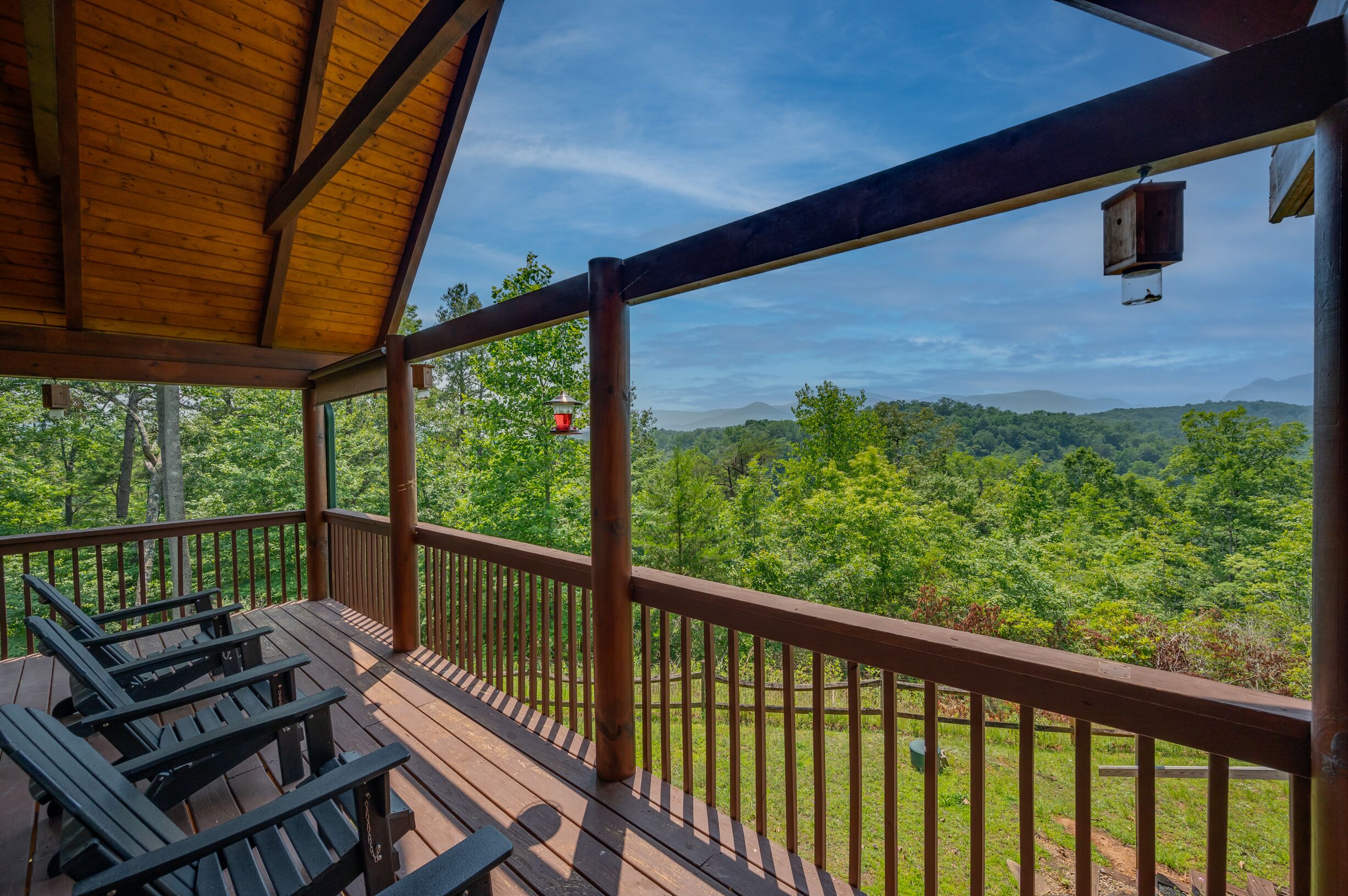 Una terraza de madera con vista a un paisaje boscoso.