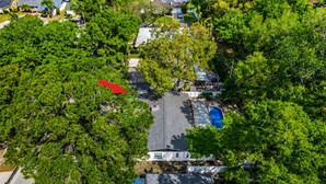 An aerial view of a residential area with houses, a swimming pool, and dense greenery. - Heated Pool, 5BR Sleeps 14, Game Table | 15 Min to Busch Gardens, Tampa (Tampa)