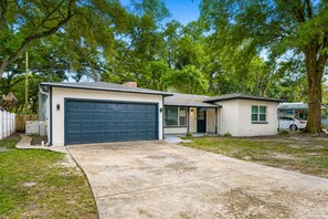A residential property with a garage, a small attached structure, and a driveway.
