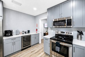 Eine moderne Küche mit grauen Schränken, Edelstahlgeräten und Holzboden.