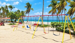 A beach with a swing set, palm trees, and a clear blue sky. - Beachfront Walk 2 Eat Million View Location (Carolina)