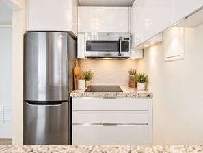 A modern kitchen with stainless steel appliances, a microwave, and a granite countertop. - Beachfront Walk 2 Eat Million View Location (Carolina)