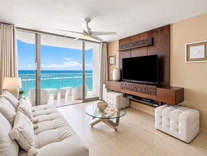 A modern living room with a large flat-screen TV, a glass coffee table, and a sofa. - Beachfront Walk 2 Eat Million View Location (Carolina)