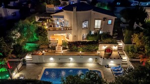 A two-story house with a swimming pool, outdoor lighting, and a balcony.