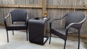 A patio area with two wicker chairs and a small table, a glass of wine, and a wooden fence in the background. - King Bed Cozy Pet Friendly Condo with Private Terrace in a Calm Gated Community (Edinburg)