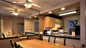 A dining area with a wooden table and chairs, a ceiling fan, and kitchen cabinets. - *7 night stay at Steamboat Springs, CO* (Steamboat Springs)