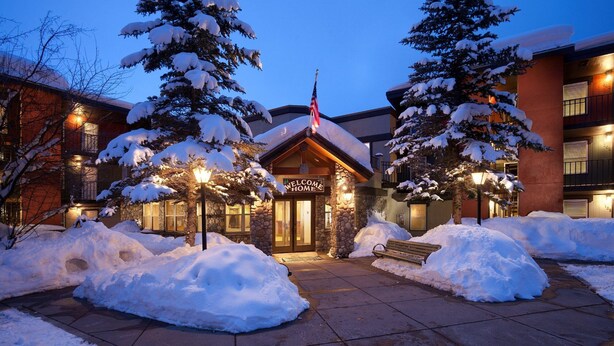 A lodge with a stone facade, a 'Welcome Home' sign, and snow-covered trees. - *7 night stay at Steamboat Springs, CO* (Steamboat Springs)