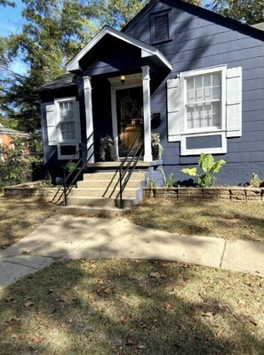 Traditional home with a front porch and potted plants.