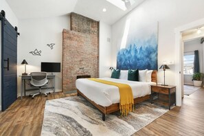 A modern bedroom with a large bed, a desk, a computer, and a painting on the wall. - 190.5 44th St. - Lawrenceville (Pittsburgh)