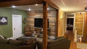 A living room with a wooden accent wall, a television, and a comfortable seating area.
