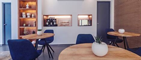 Une salle de réunion moderne avec une table en bois, des chaises bleues, une étagère intégrée agrémentée d’objets décoratifs et un climatiseur fixé au mur.