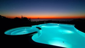 A swimming pool with a sunset view, surrounded by a fence and vegetation. - Top location - tranquillity - pool - garden & sea view (Zambrone)