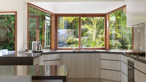 Una cucina moderna con ampie finestre, mobili in legno e piano cottura integrato.