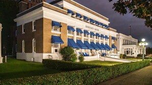 A large, historic building with a prominent name on the facade, multiple balconies with blue awnings, and a well-maintained lawn. - Waterfront! Firepit~3 King bedrms~playroom~kayaks~near restaurants (Hot Springs)