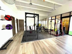 Work out in style with a fully equipped gym featuring a squat rack, bench press, cable machine, exercise balls, and a climbing ladder.