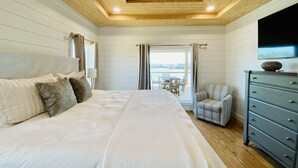 Ein Schlafzimmer mit einem großen Bett, einem Schminktisch, einem Sessel und einem Deckenventilator.