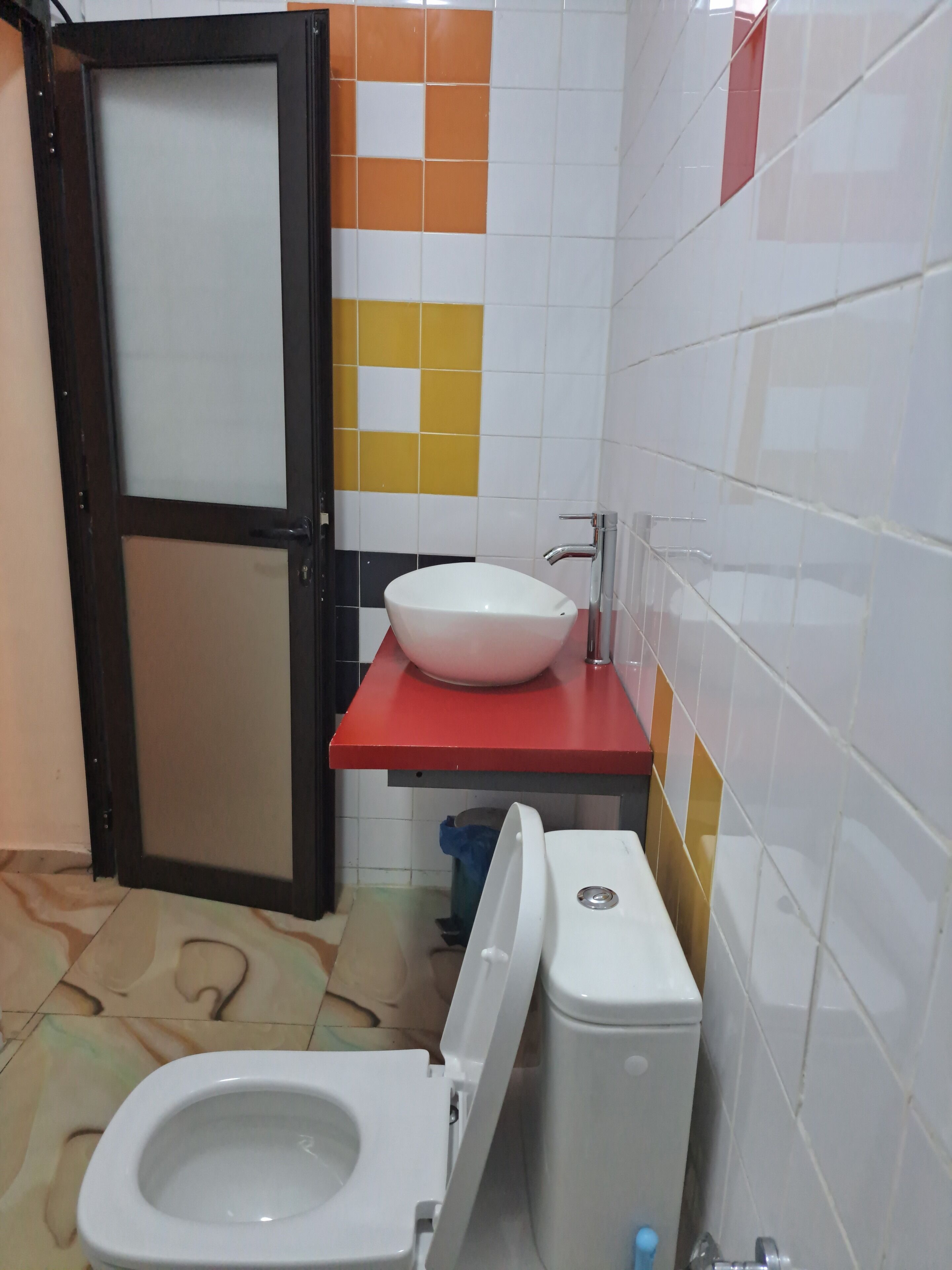 A small bathroom with a toilet, a sink, and a door.