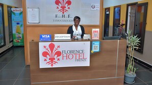 A reception desk at Florence Hotel in Yamoussoukro, with a logo, a Visa accepted sign, a reception sign, and a QR code for scanning. - Florence Hotel Firenze Yamoussoukro (Yamoussoukro)