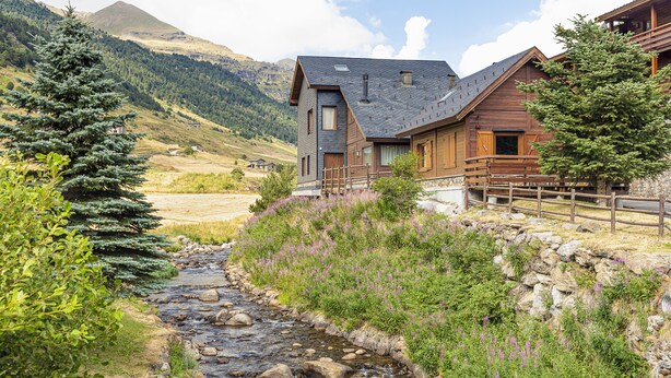 A rustic mountain cabin with a stone foundation, wooden exterior, and a small porch. - 𓃹 By Grandvalira: 2BD Duplex & Free Parking (Canillo)