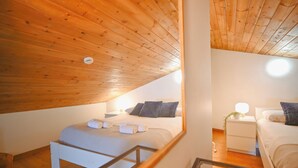 A bedroom with a wooden ceiling, a bed with pillows, a bedside table with a lamp, and a nightstand with a plant. - 𓃹 By Grandvalira: 2BD Duplex & Free Parking (Canillo)