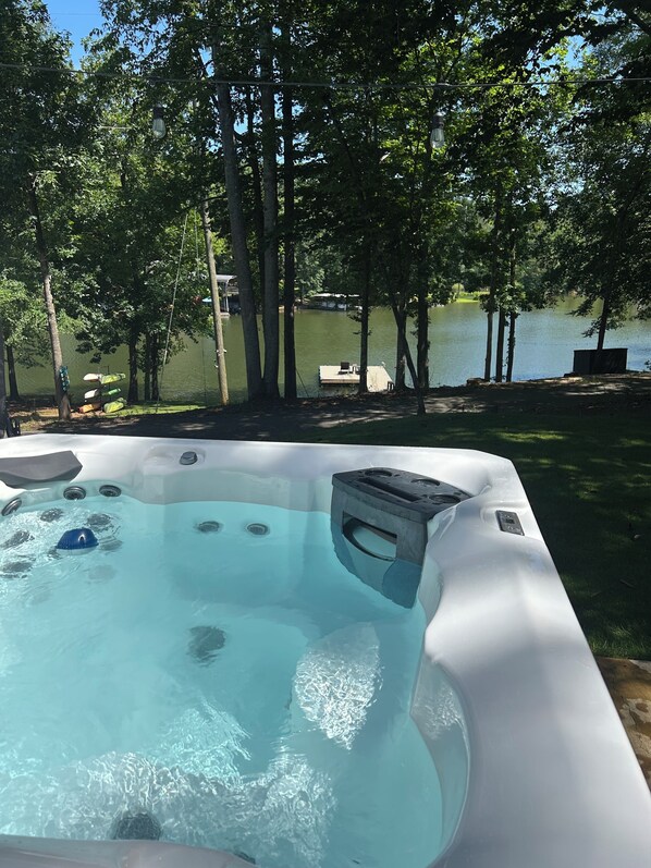 A hot tub with a view of a lake and trees.