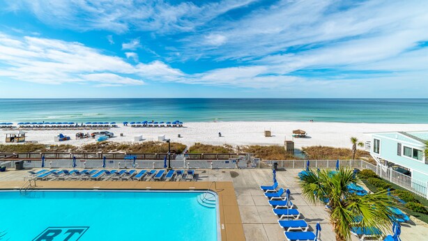 A pool area with lounge chairs and a view of the beach. - Beach Memories Made Here-The Memory Maker Regency Towers 407-Beachfront-2Bd/2Ba-Sleeps 8 (Panama City Beach)