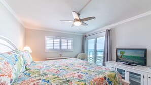 A bedroom with a bed, a ceiling fan, a TV, and a balcony with a view. - Beach Memories Made Here-The Memory Maker Regency Towers 407-Beachfront-2Bd/2Ba-Sleeps 8 (Panama City Beach)