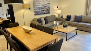 Una sala moderna con comedor, un conjunto de sofá y una mesa de centro.
