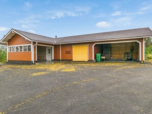 A two-story building with a garage, a front door, and a covered driveway.