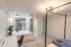 Une salle de bain moderne avec une douche à parois de verre, un grand miroir et un luminaire encastré au plafond.