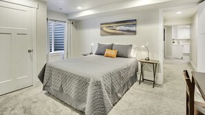 Une chambre à coucher avec un grand lit, une table de chevet, une lampe et un tableau au mur.