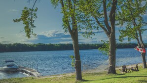 Une jetée au bord du lac, avec un bateau, un hamac et des sièges d’extérieur.
