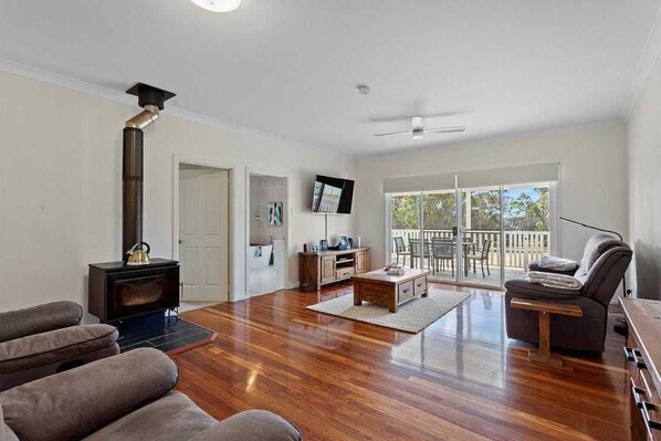 Relax in this cozy living space with a fireplace, outdoor views, and a comfortable seating area.