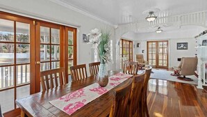 Un coin repas avec une table en bois, des chaises et un vase de fleurs.