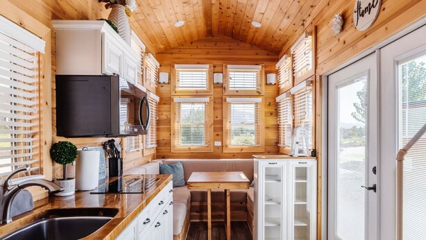 A compact kitchen with wooden walls, a built-in stove, and a sink.