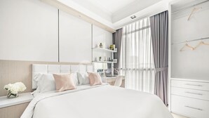 Een moderne slaapkamer met een groot bed, een bureau en een kledingkast.