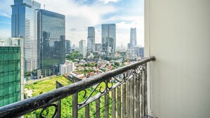 Stadsbeeld met moderne wolkenkrabbers en een uitzicht vanaf een balkon met een metalen hekwerk.