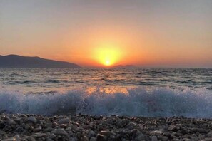 A sunset over a rocky beach with waves crashing onto the shore. - 2 Bed Apt Sleeps 6  -Balcony - 5-Mins from seaside (Vlorë)