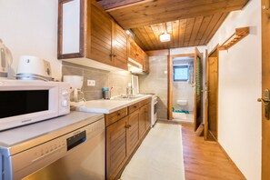 A kitchen with wooden cabinets, a microwave, a dishwasher, and a sink.