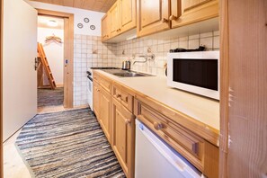 A kitchen with wooden cabinets, a microwave, a sink, and a stove.