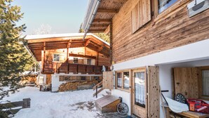 A wooden cabin with a covered porch, a wooden staircase, and a snow-covered ground. - Hochfügenblick - Relaxation for Two (Hochfügen)