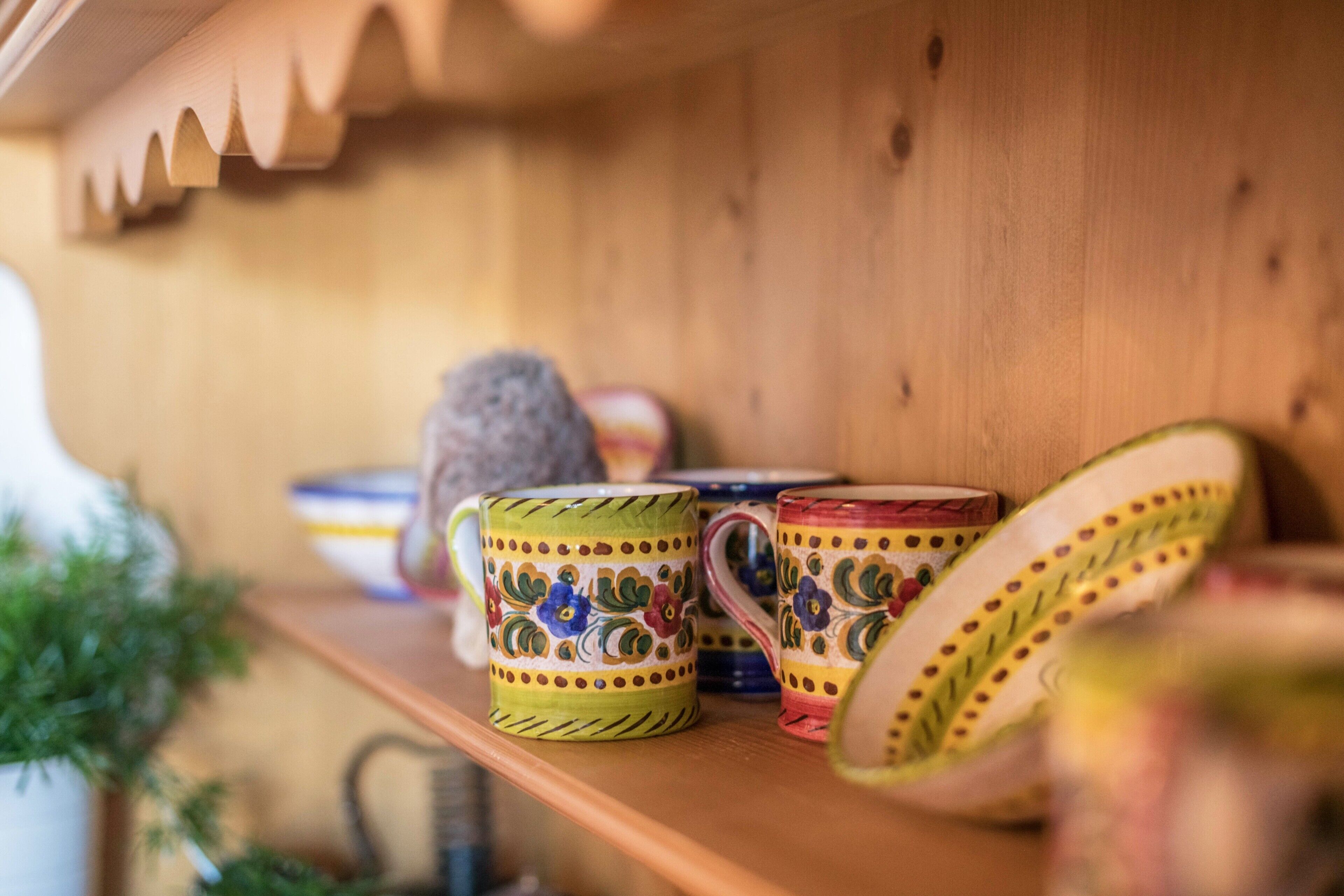 A shelf with ceramic mugs and bowls.