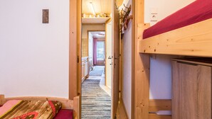 A narrow corridor leading to a room with a bunk bed, wooden walls, and a visible door. - Hochfügenblick - Relaxation for Two (Hochfügen)