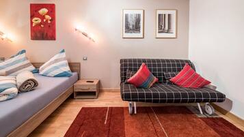 A modern room with a bed, sofa, and artwork on the walls.