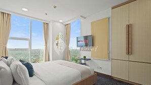 Un dormitorio moderno con una cama grande, un televisor en la pared y un armario.