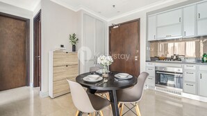 A modern kitchen with a dining area, featuring a round table, chairs, and a built-in oven.