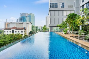 A swimming pool with a clear view of surrounding buildings and greenery.