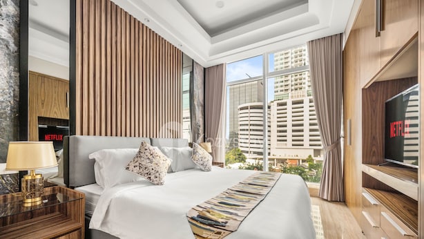 A modern hotel room with a large bed, a TV, and a view of the cityscape. - MAPLE by Kozystay (Jakarta)