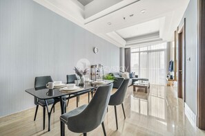 Un comedor moderno con una mesa larga, sillas y un reloj en la pared.